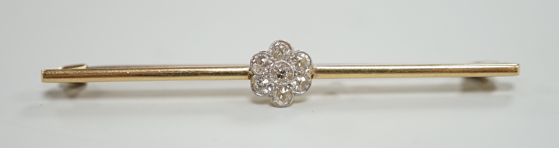An 18ct and seven stone diamond set flower head cluster bar brooch, 57mm, gross weight 4.7 grams.